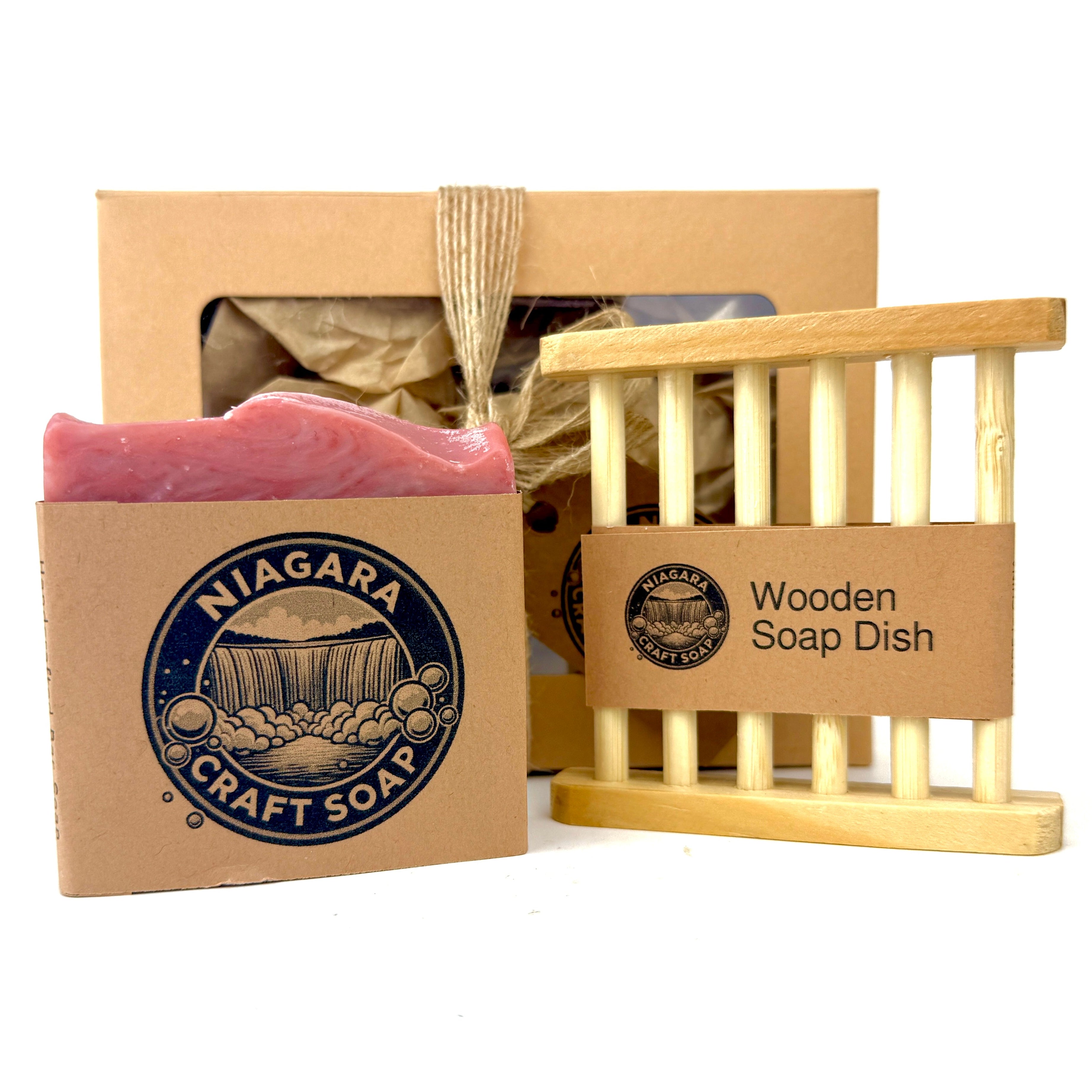 A Niagara Craft Soap Gift Set including a bar of soap and a wooden soap dish, packing is a craft paper box with cellophane window wrapped in a jute fibre bow