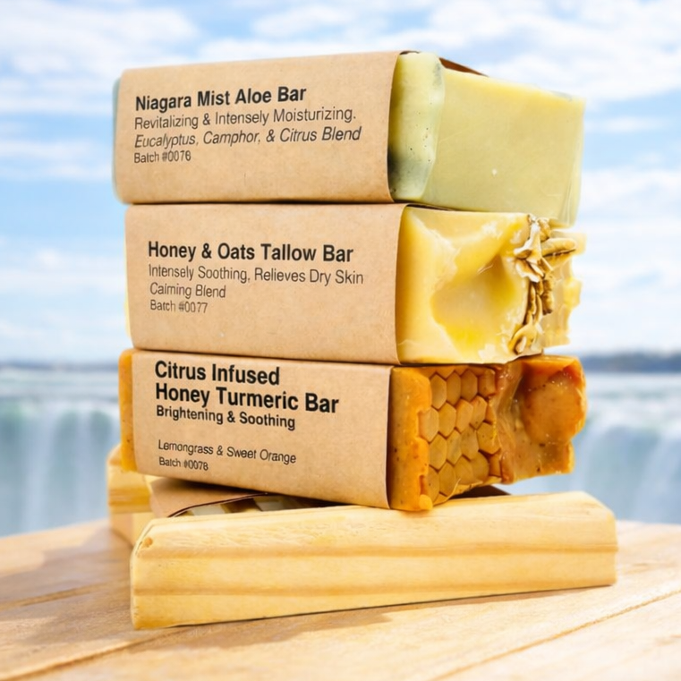 Stack of soap bars with labels on a wooden platform by a scenic waterfront.