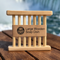 Large wooden soap dish on a wooden surface with a blurred waterfall background