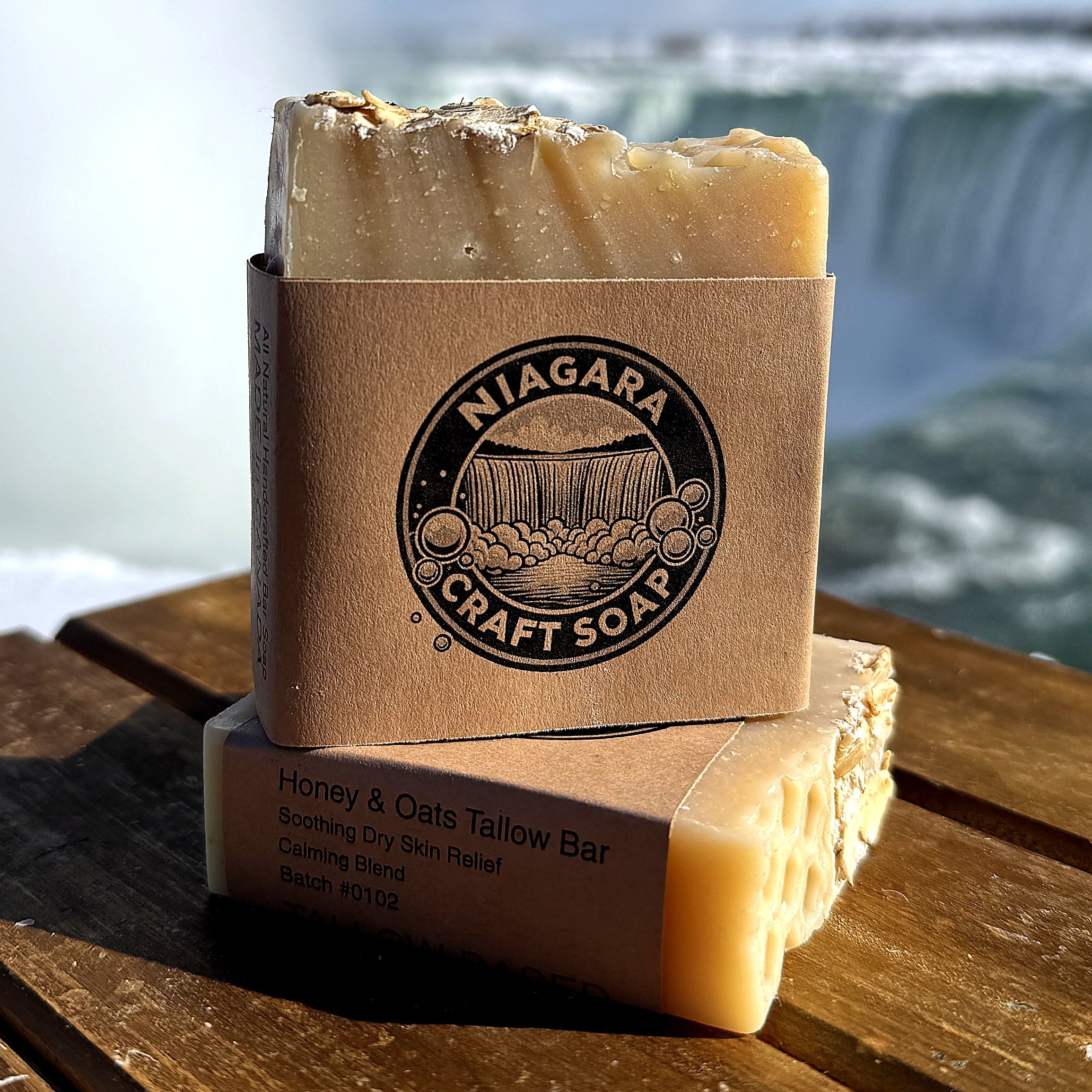 Two bars of soap in front of a scenic waterfall