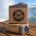 Niagara Craft Soap patchouli bar on a wooden surface with a blurred natural background