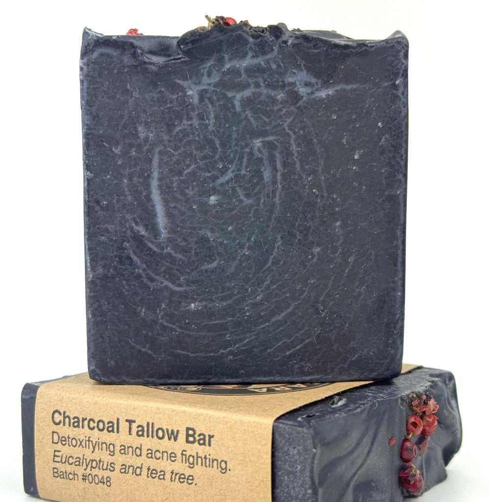 Bar of charcoal soap with packaging on a white background