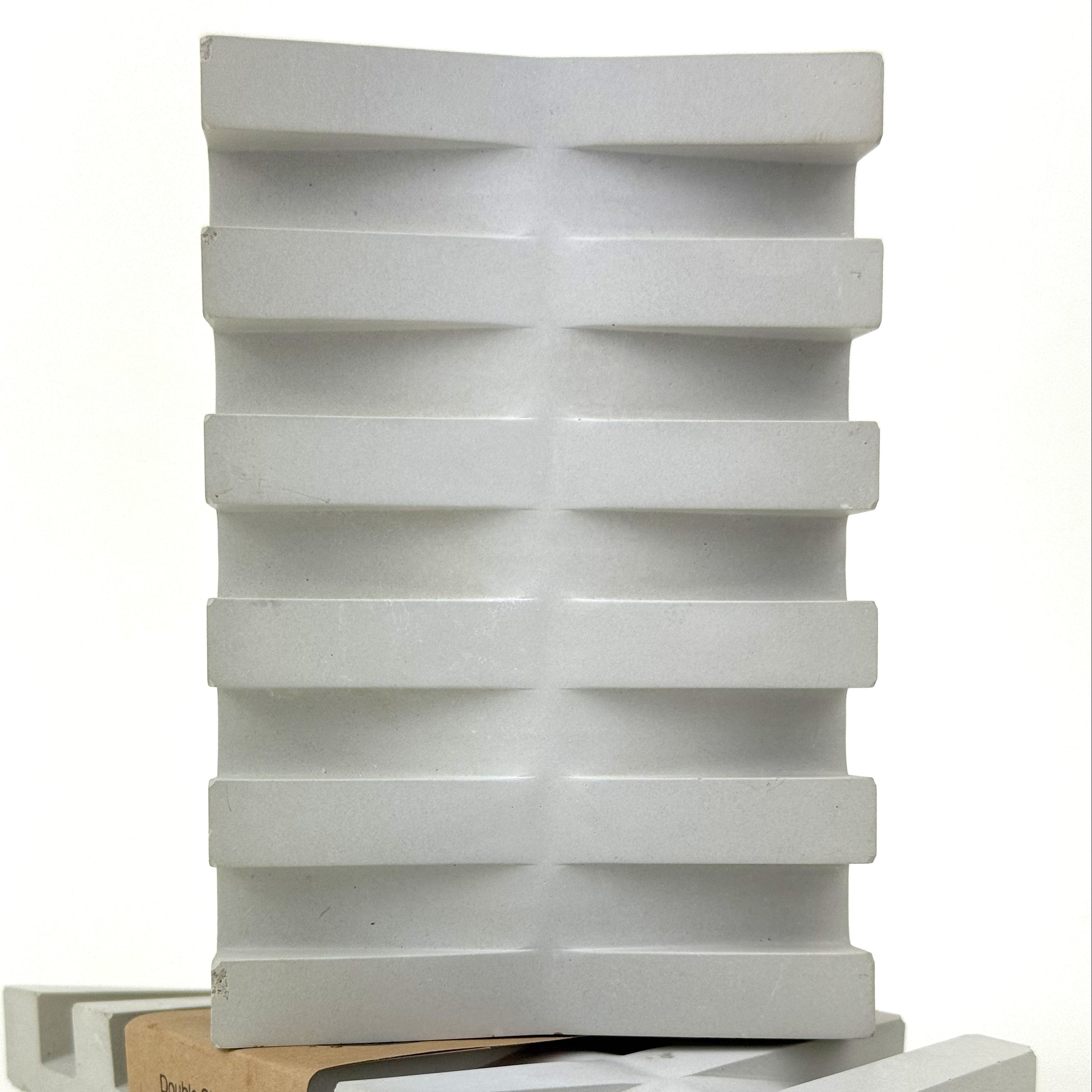 concrete soap dish that drains along both sides on a white background